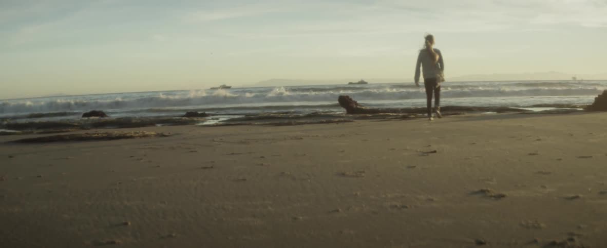 A girl running on the beach towards the water