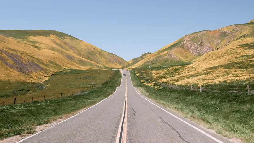 A vehicle drives on a rural road