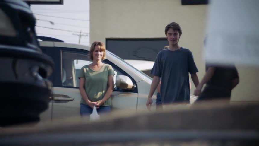 The children play in the lot as a woman watches