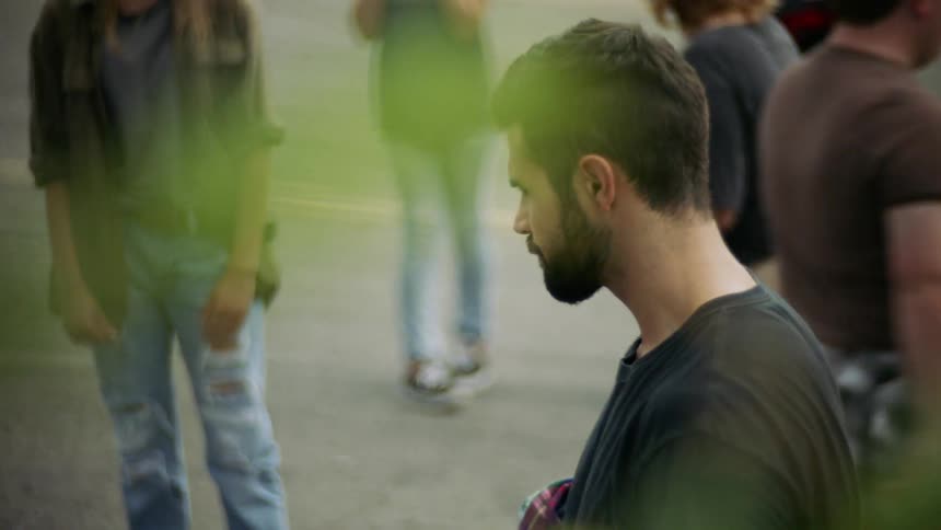 A man is standing outside drinking from a bottle of water