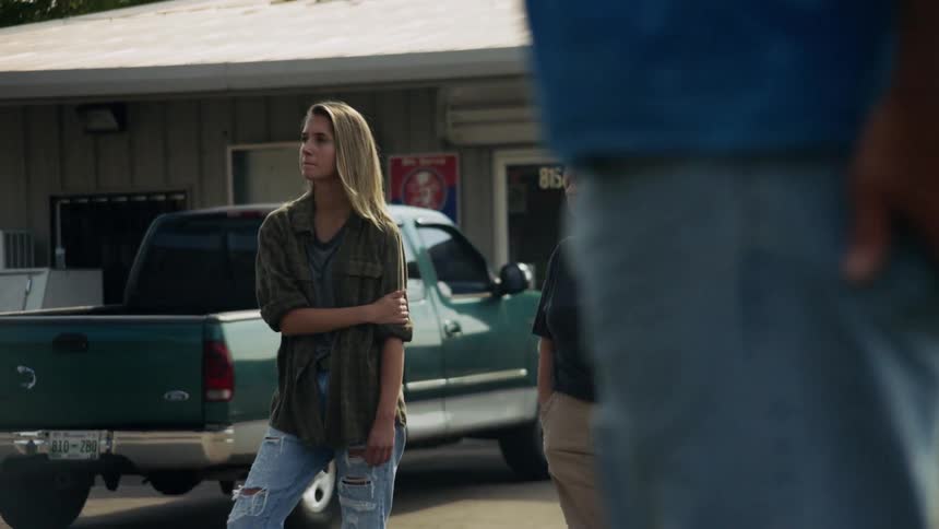 People look out from a store parking lot