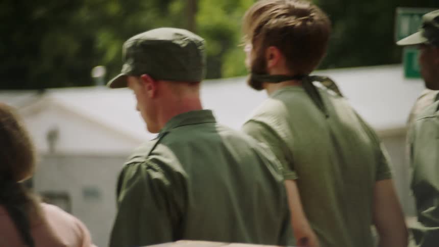 Soldiers stand with two prisoners