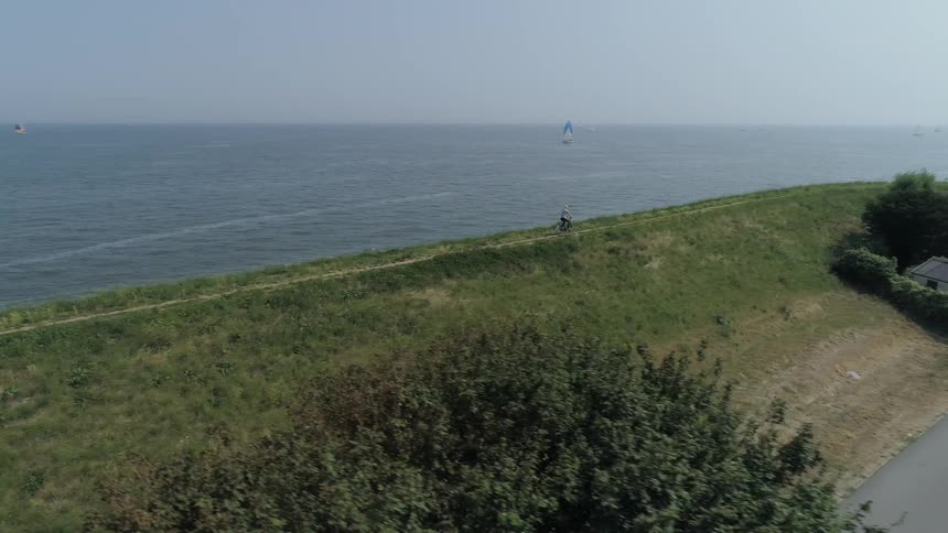 A bicyclist rides along a coastline