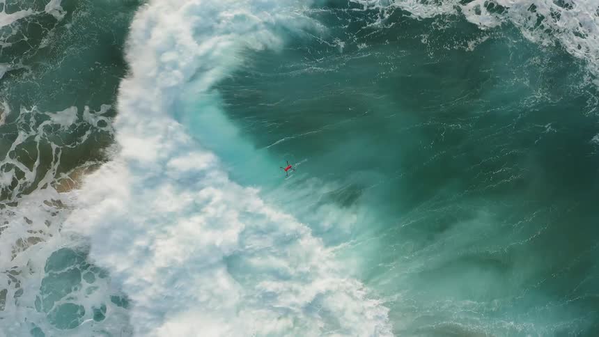 A drone flies over ocean waves
