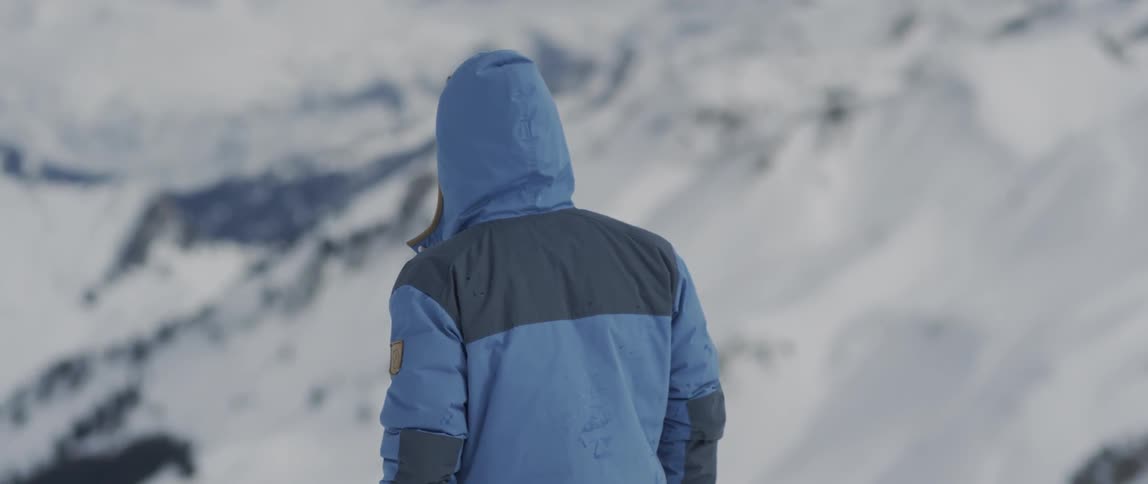 A man hikes in snowy mountains