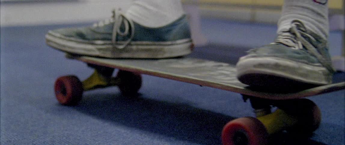 A person wearing sneakers pushes a skateboard back and forth