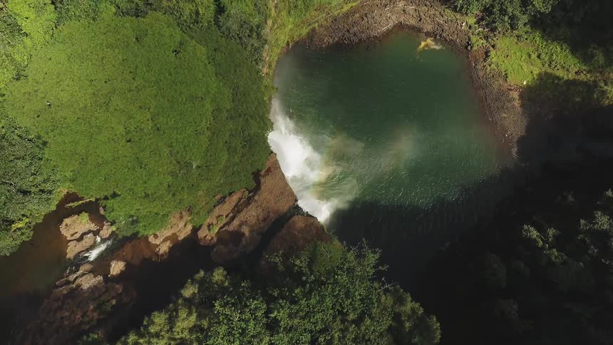 The tall cliff has a waterfall on the side