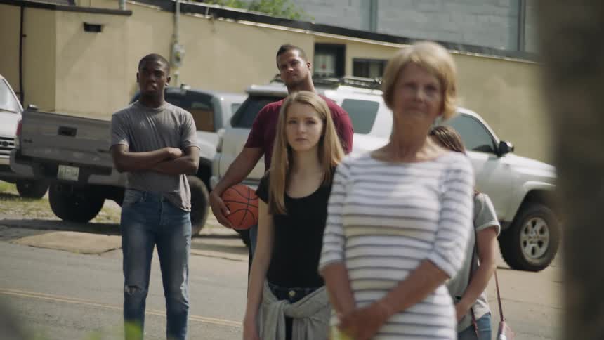 People stand in the lot and one is holding a basketball