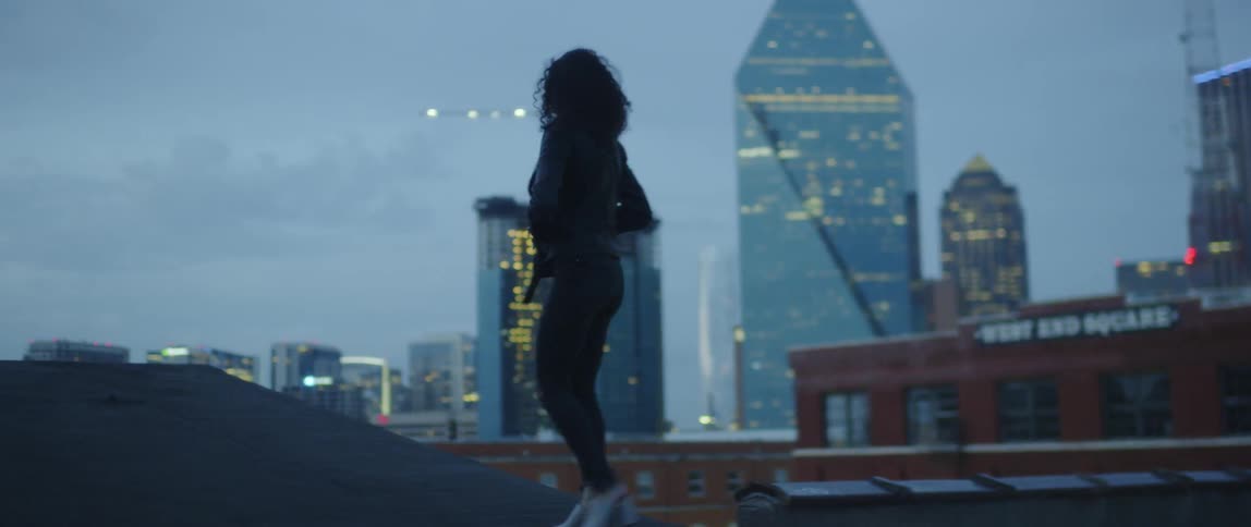 Woman walks on a city rooftop