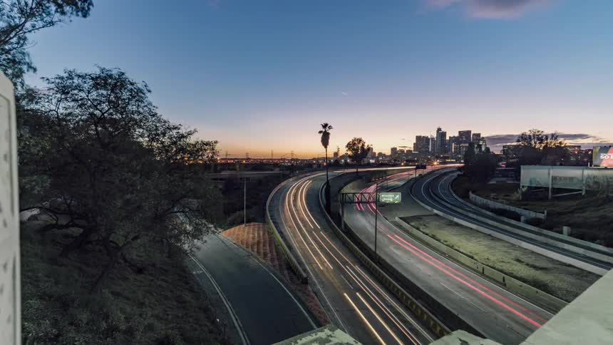 The cars travel around the turn in the highway