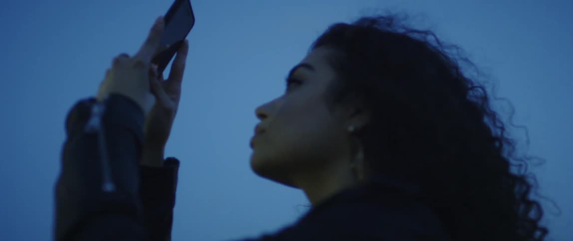 A woman holds her phone up outside