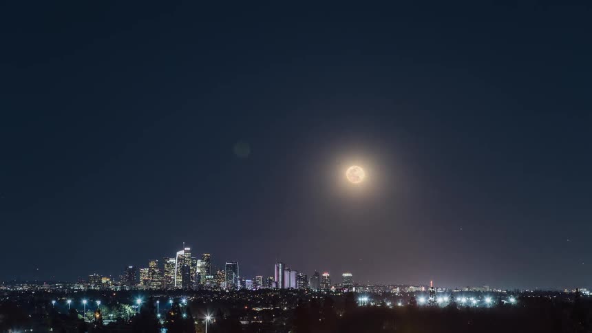 Timelapse of the moon rising over a city