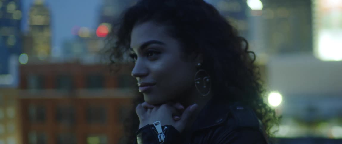 A woman looks up at the sky in the city