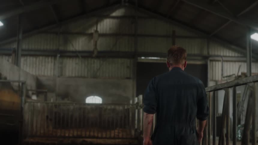 A man walks through a barn building