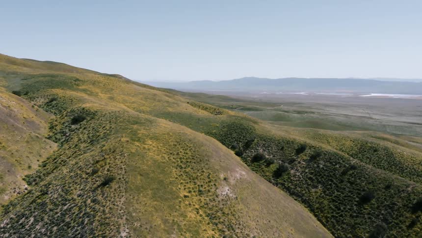 The green hills move into the distance