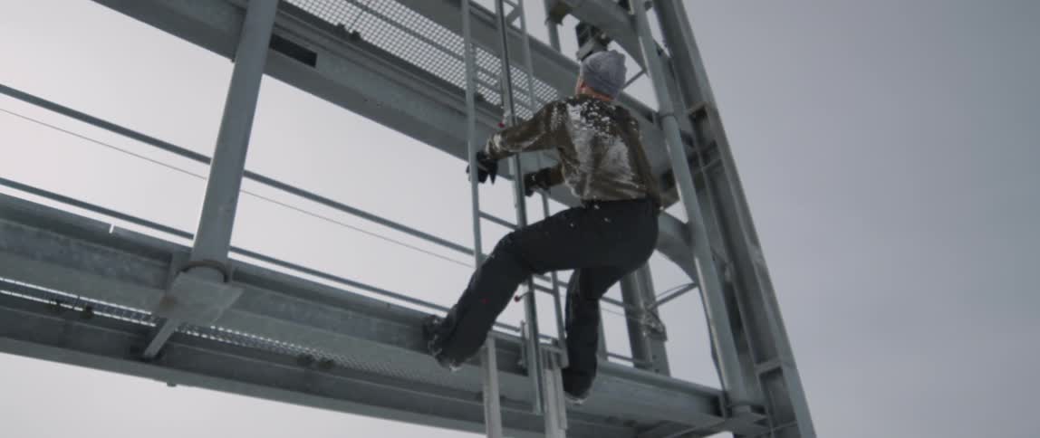 A man climbs up the ladder by the billboard