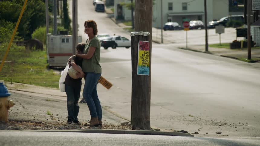 A woman hugs her child on the corner