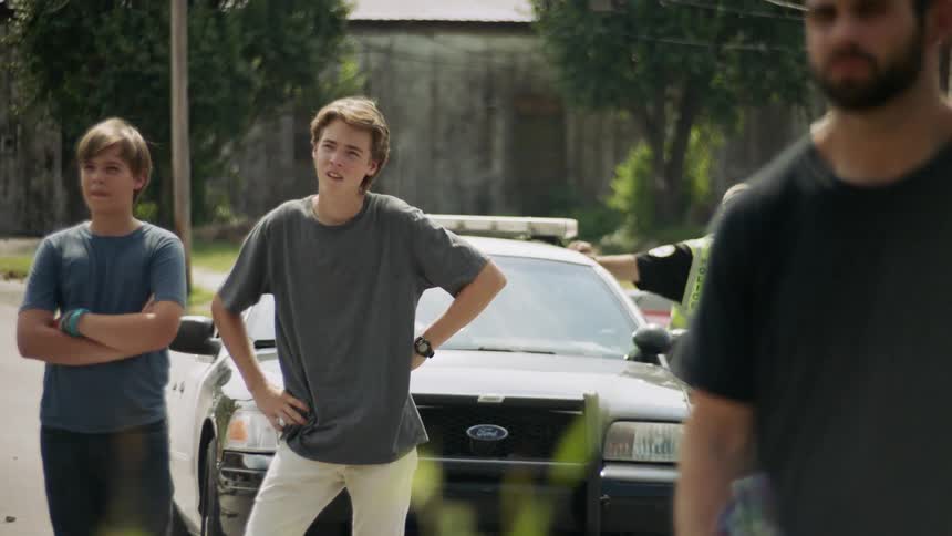 People stand outside watching by the car