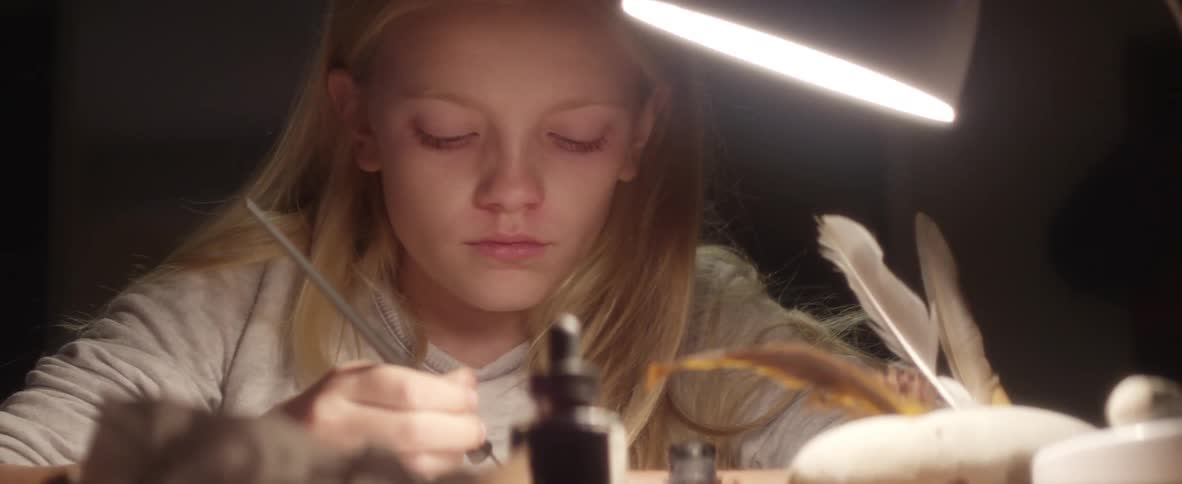 A girl drawing under a light