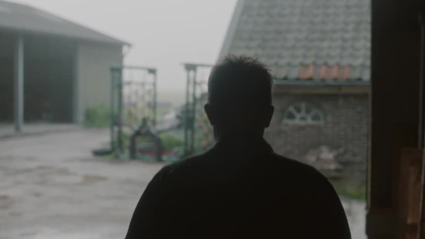 A man walks out of the barn on the farm