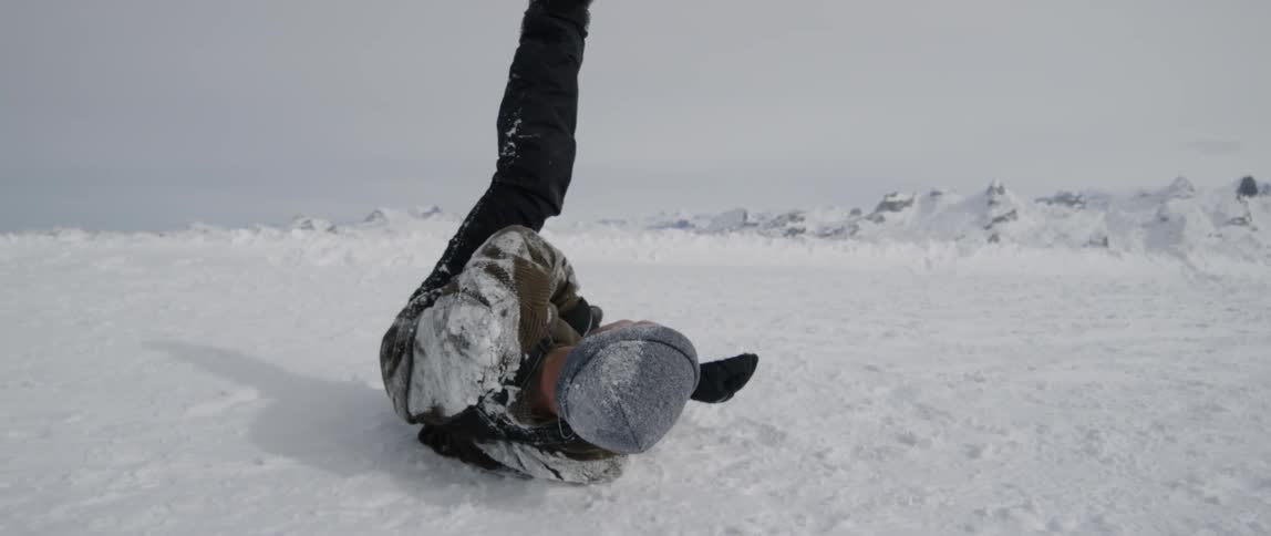 A man rolls around in the snow