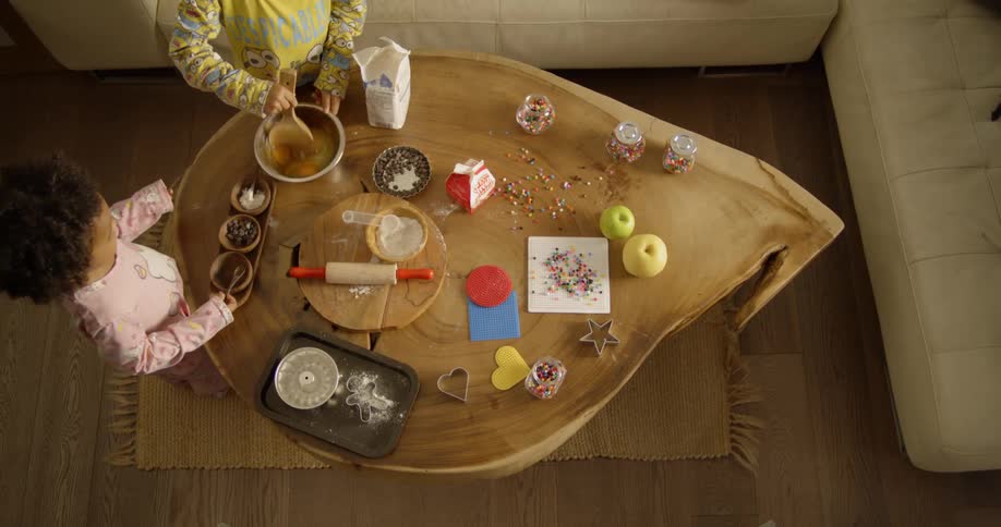Two children work near a table covered with art supplies