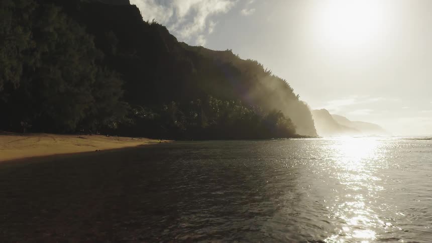 Calm water on a beach next to a jungle