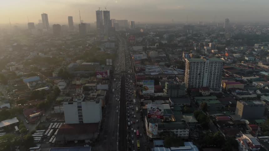 Traffic is backing up on a freeway leading into a city at dawn