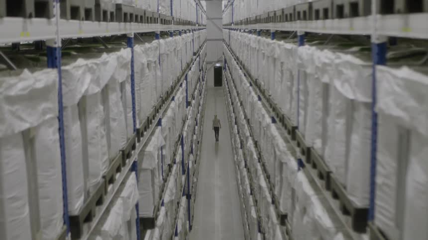 A woman walks through a packing warehouse