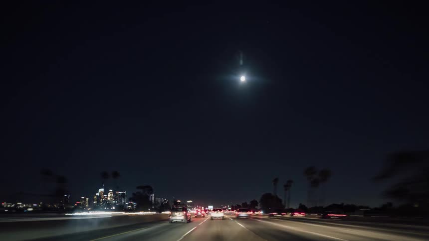 Vehicles travel down a highway at night