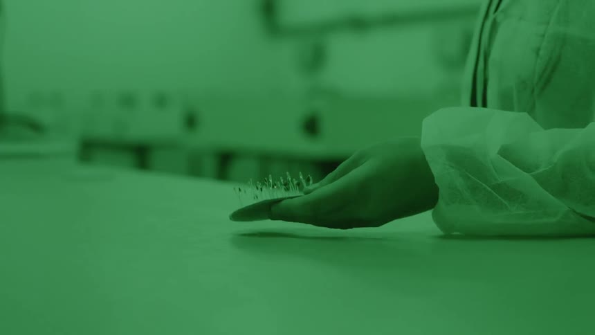 A person in a lab is carrying samples to a table