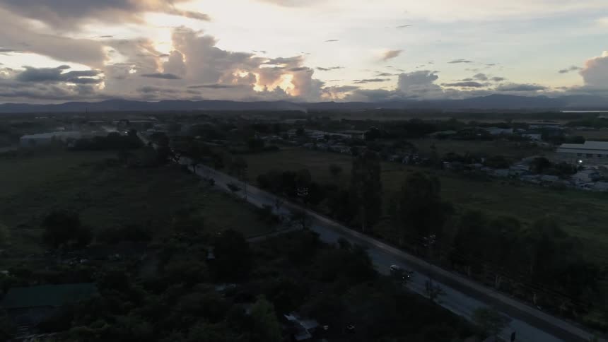 The cars drive down the road at sunset