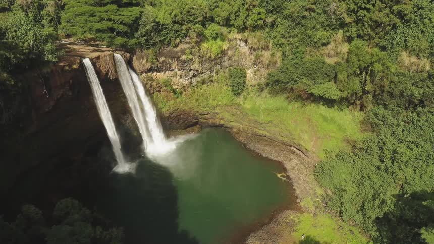 The waterfall pours into the spring below