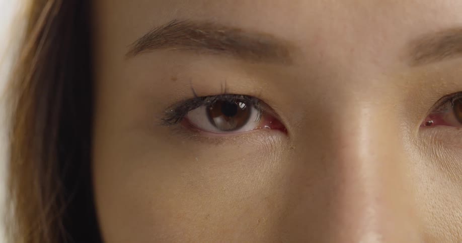 Extreme closeup of a woman's eye going from closed to open