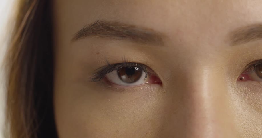 A woman looking forward blinks