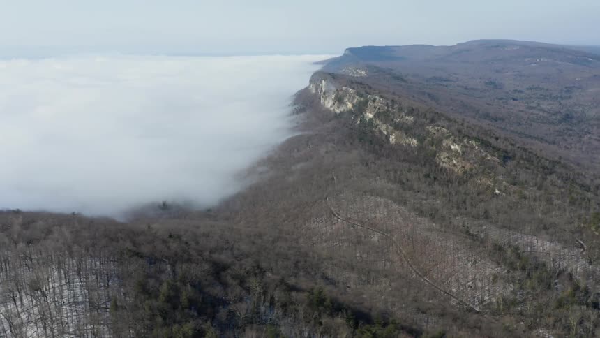 The clouds are creeping over the mountain top