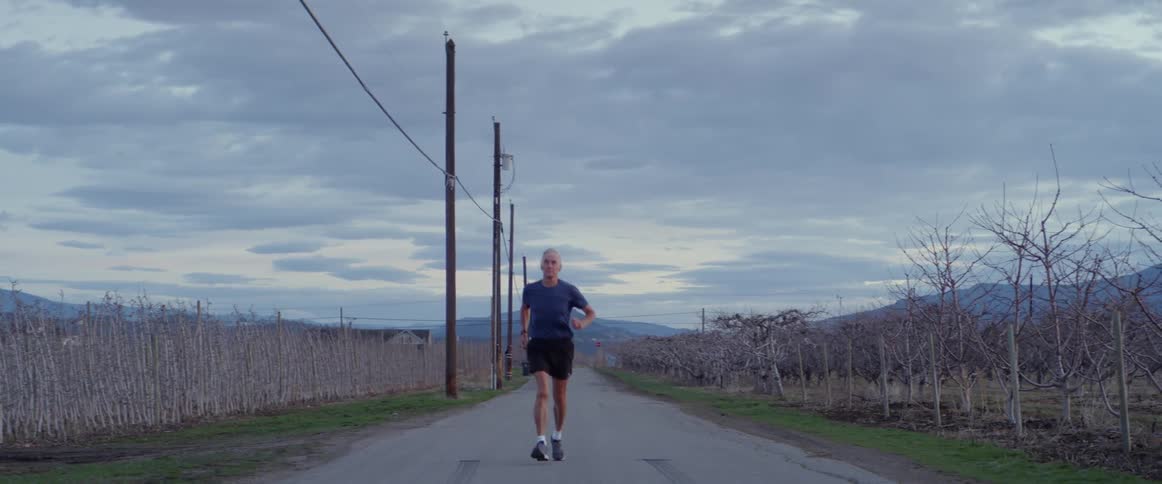 Man runs on a rural road at sunset