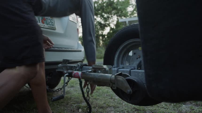 Man attaches a trailer to an suv