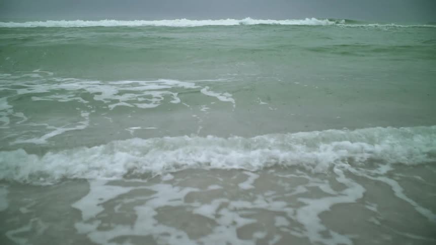 The waves slowly crash moving towards the shore