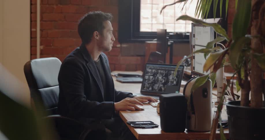 A man is sitting down at a desk to begin working during the day