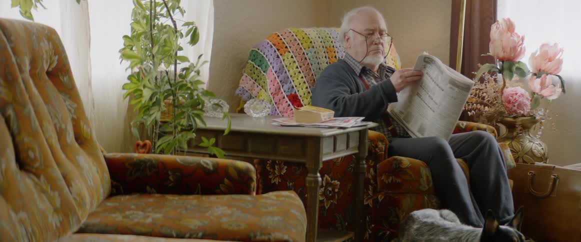 A man sits on his chair reading a newspaper
