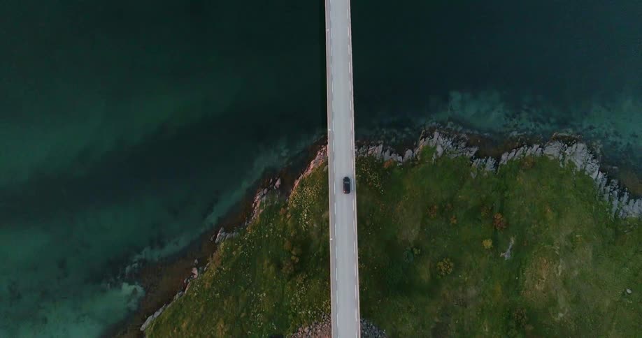 The cars begin to cross the long bridge