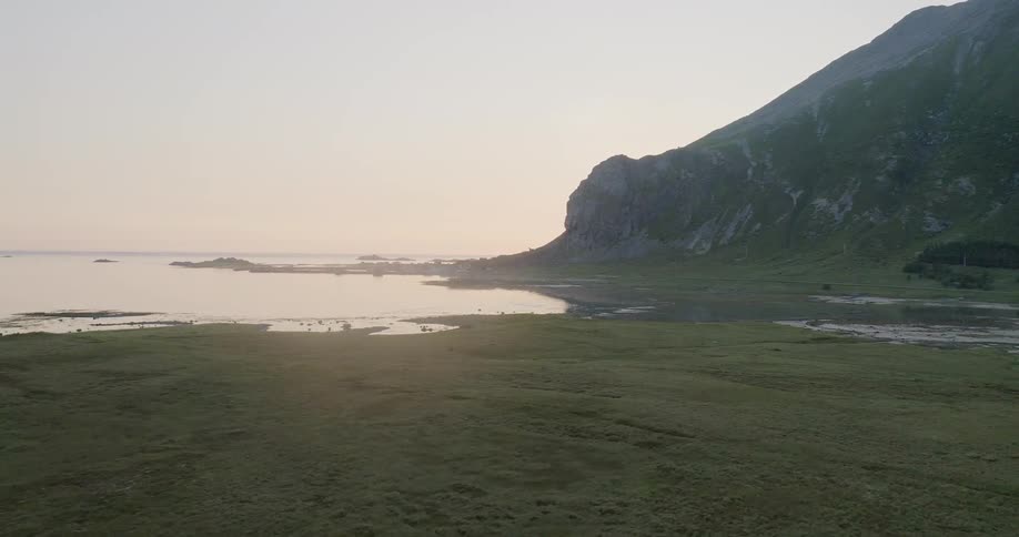The green fields lead right up to the water at sunset