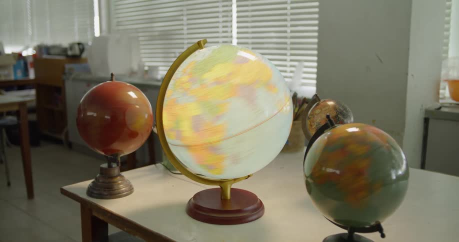Three spinning globes on a table and one globe stops