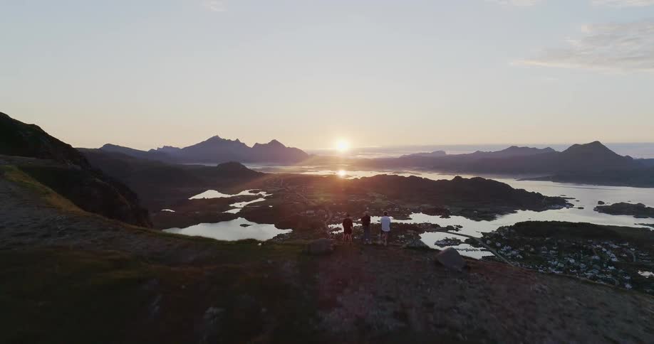 People stand on the mountain looking over the shore