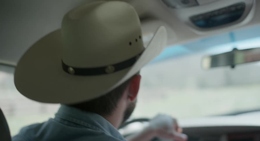 A cowboy drives a truck