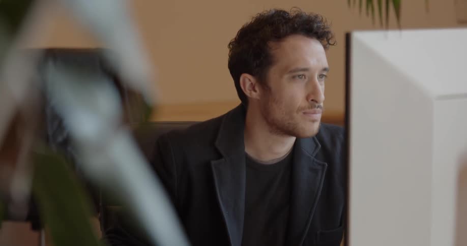 A man looks over the monitor as he types