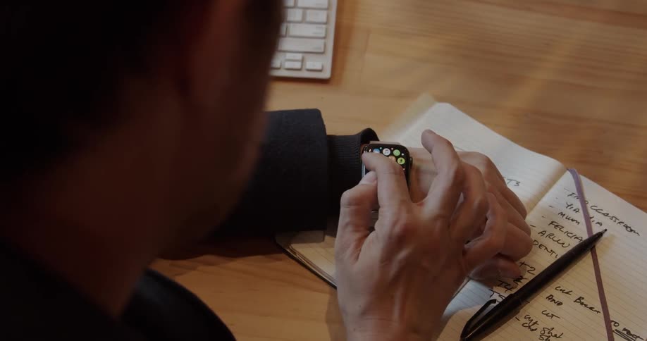 A man uses his watch in the office