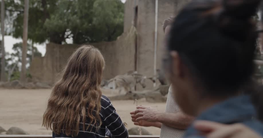 A man points towards a stone building with a girl
