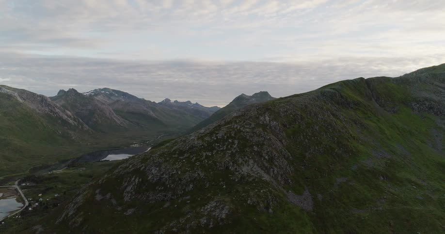 Mountains stand tall under a cloudy blue sky